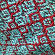 a close up view of a red and blue crocheted blanket