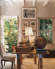 a living room filled with lots of furniture and pictures on the wall above it's windows