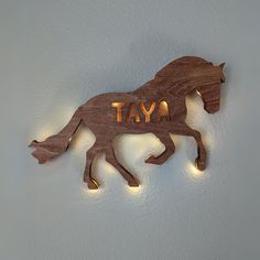 a wooden horse with the word tay written on it's side and lights in the shape of a horse