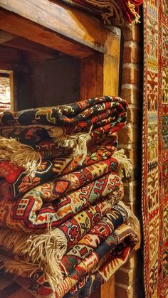 many rugs are stacked on top of each other