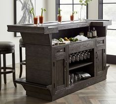 a bar with two stools in front of it and some plants on the counter