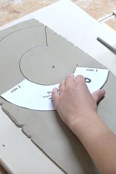 a person cutting out a piece of paper with scissors