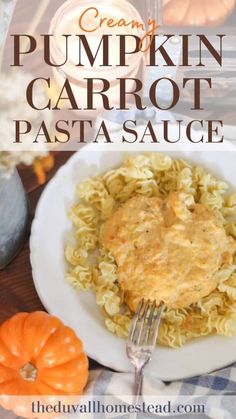 creamy pumpkin carrot pasta sauce on a white plate with a fork and some mini pumpkins in the background