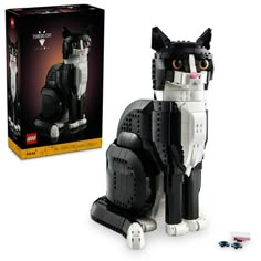 a cat made out of legos sitting next to a box