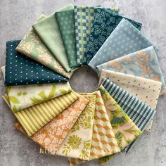 a bunch of different colored fabrics arranged in a circle