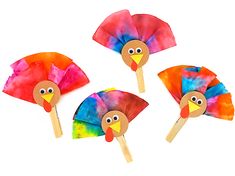 three handmade turkeys on sticks with colored paper and wood stick sticking out of them