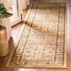 a large rug is sitting on the floor next to a vase with flowers in it