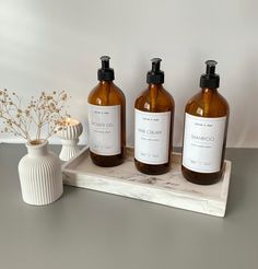 three bottles of soap sit on a tray