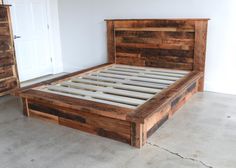 a bed frame made out of wooden planks in a room with concrete flooring