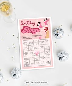 a pink birthday party game with disco balls and confetti on the table next to it