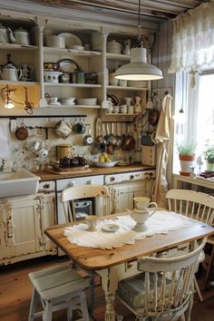 an old fashioned kitchen with white cabinets and wooden table in front of the stove top oven