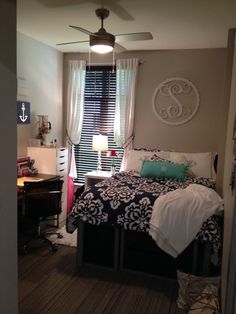 a bed room with a neatly made bed and a ceiling fan