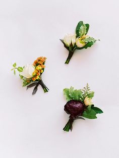 three boutonnieres with different flowers on them