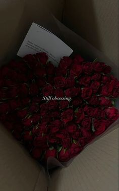 a box filled with lots of red roses