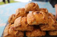 a pile of fried food sitting on top of a black plate next to a blue table cloth