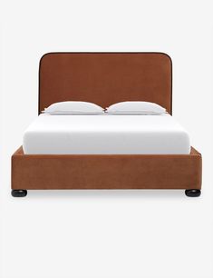 a bed with a brown headboard and white sheets