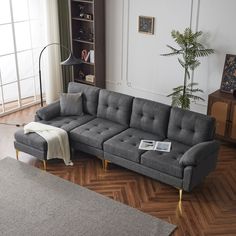 a grey couch sitting on top of a wooden floor