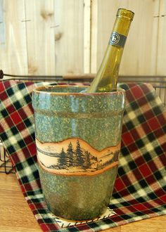 a bottle of wine sitting in a bucket on top of a table