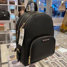 a black michael kors backpack on display in a store