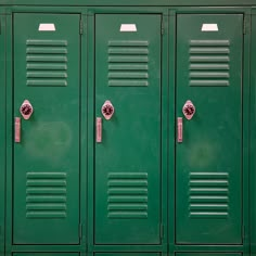 two rows of green lockers with metal handles