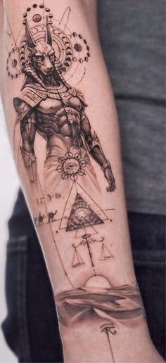 a man's arm with tattoos on it and an image of the egyptian god