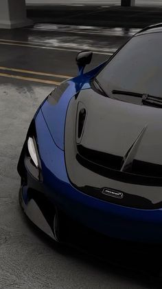 a blue and black sports car parked on the street