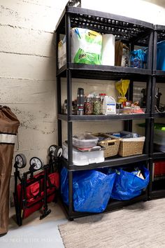 a shelf filled with lots of items next to a bag and some bags on the floor