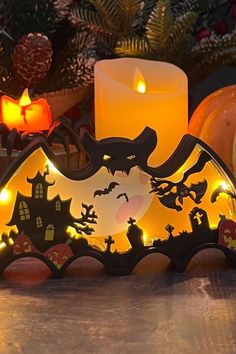 a lighted candle holder with halloween decorations and candles