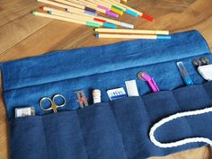 a blue bag with scissors, pencils and other items in it