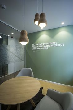 a conference room with green walls and wooden tables in the center, surrounded by gray chairs