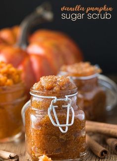 two jars filled with sugar and cinnamon sitting on top of a table next to cinnamon sticks