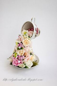 a teacup with flowers in it sitting on a saucer