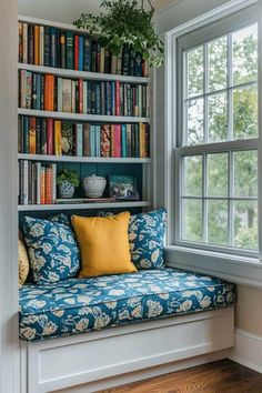 a window seat in front of a bookshelf filled with books