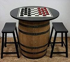 a chess board on top of a barrel with stools next to it and a table