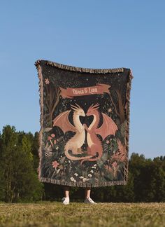 a woman standing in front of a tapestry with a dragon on it's back