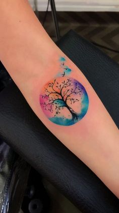 a woman's arm with a tree tattoo on it