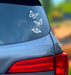 three butterflies stickers are on the back of a car's tail end window