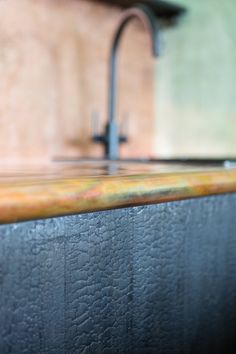 a kitchen counter top with a faucet and sink in the backround