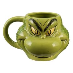 a green ceramic mug with an angry grin face