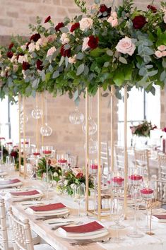 a long table with white chairs and red napkins on it is set up for a formal function