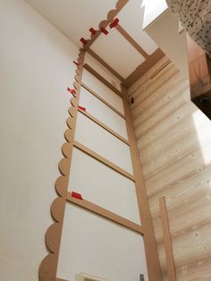 an unfinished room with white walls and red tape on the wall next to a ladder