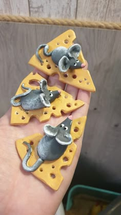 three mice on cheese slices in the palm of someone's hand