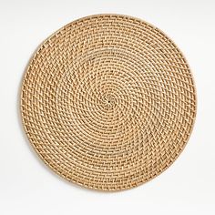 a round woven placemat on a white surface with no one in the photo looking at it