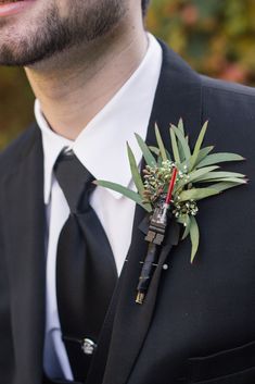 a man wearing a suit and tie with a boutonniere on his lapel