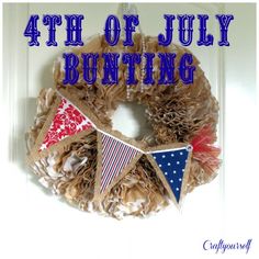 a fourth of july wreath hanging on a door with the words 4th of july bunting