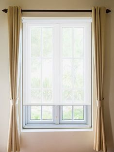 an open window with curtains hanging in front of it