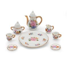 an assortment of porcelain tea and coffee set with flowers on the side, including saucers