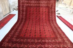 a large red rug is laying on the ground