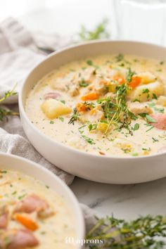 two white bowls filled with soup and garnished with parsley on the side