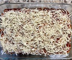 a casserole dish with cheese on top in a glass baking pan, ready to be baked